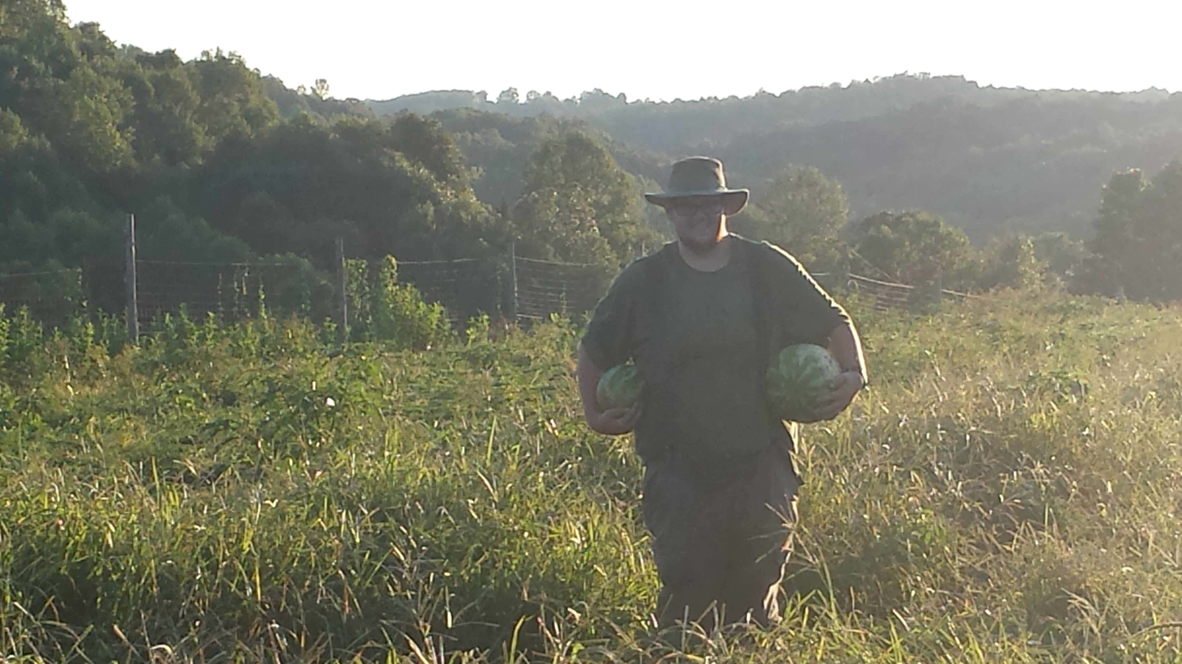 chris with watermelons in field farm